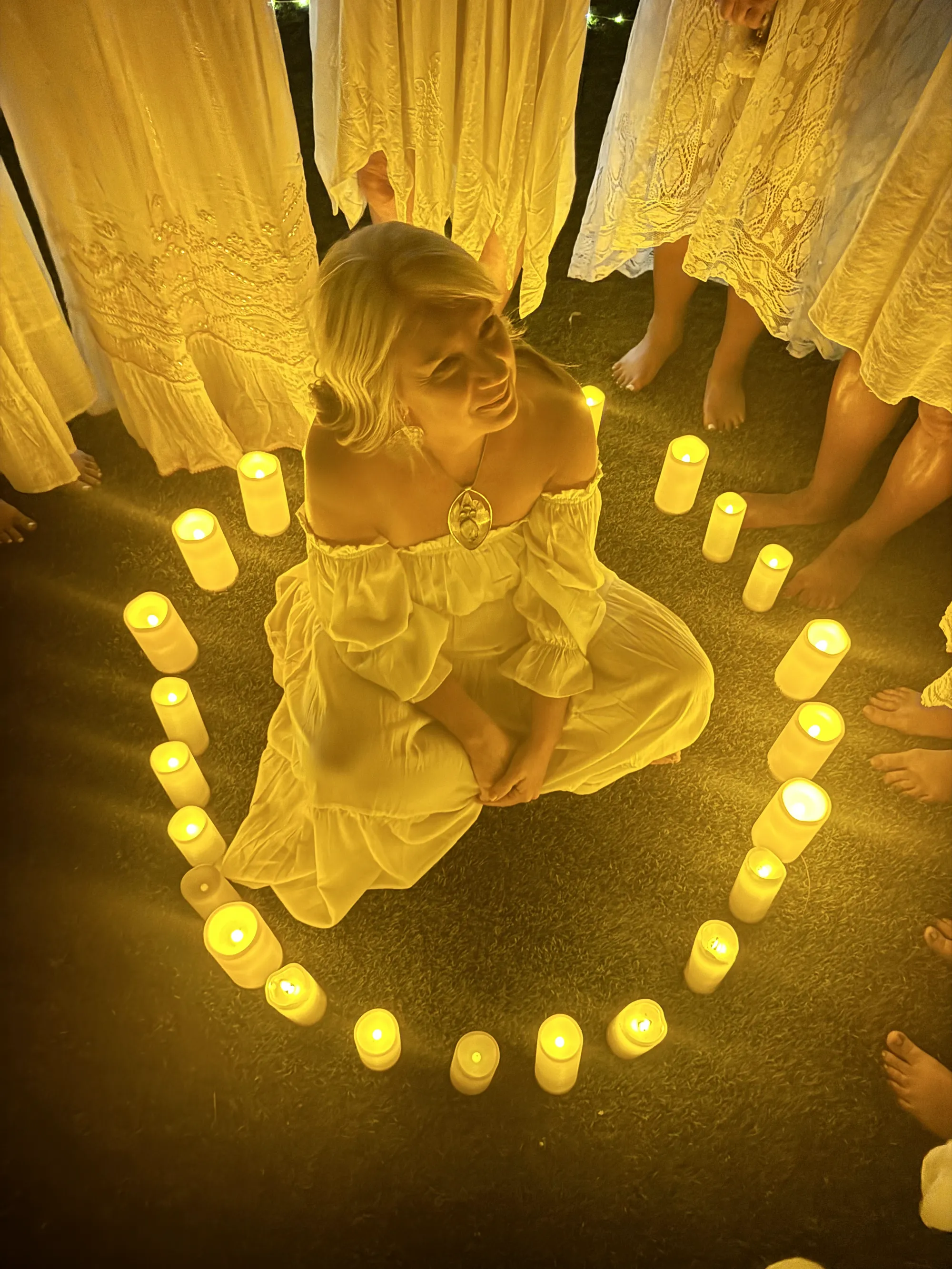 Wendy at the center of a circle of candlelight, held by the group